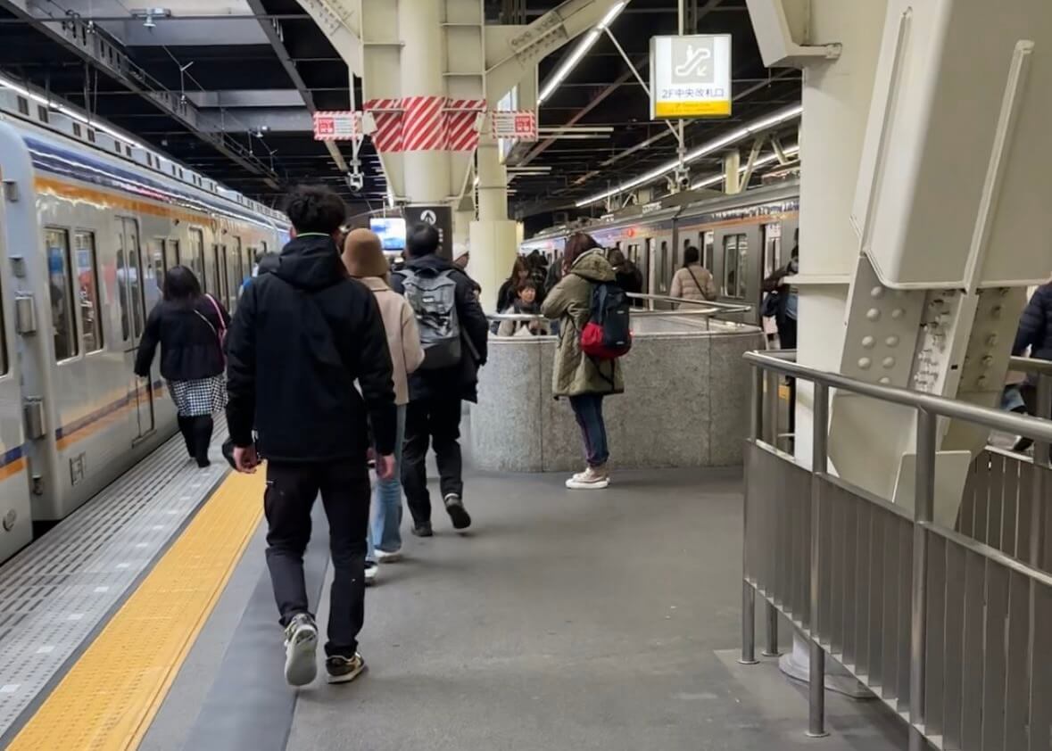 people stood next to a stationary train on the platform