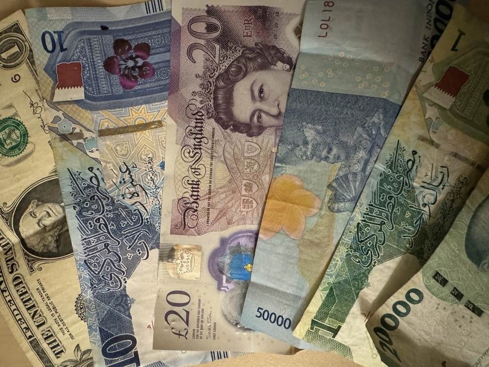 A dollar bill, british pound sterling twenty pound note, indonesian money, rupia, qatari money.