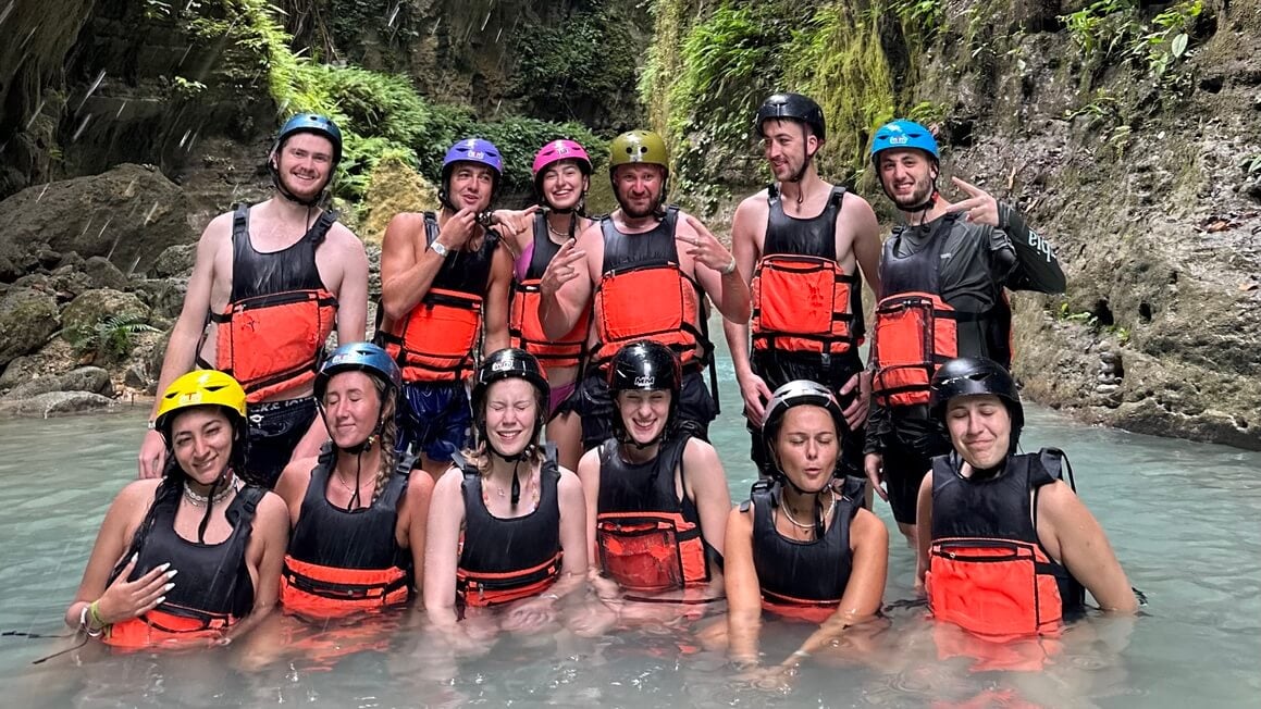 Friends pose amidst the beautiful scenery of Kawasan Falls during their canyoneering expedition