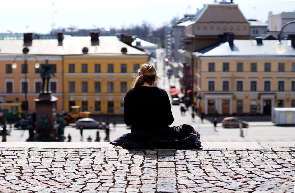 woman sitting on a wall looking down on Helsinki city centre