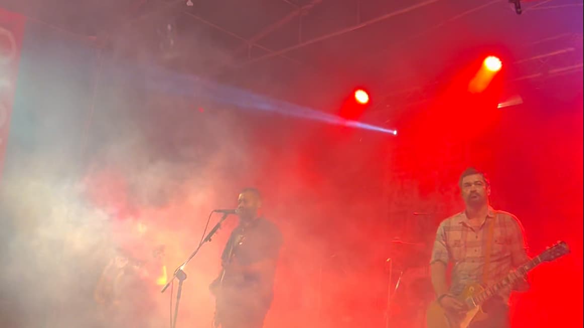 A local band playing guitar and singing on stage at a festival in pico island, the azores, portugal.