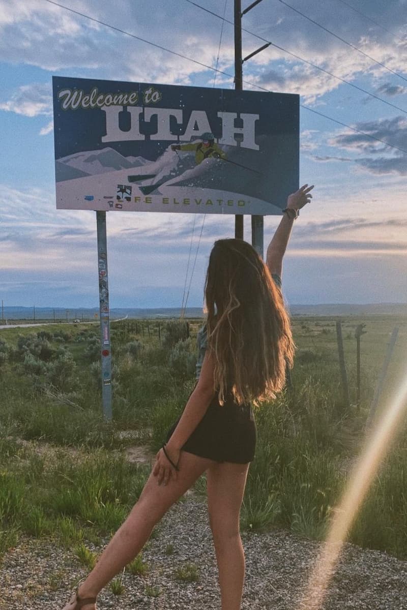 amanda standing in front of the 'welcome to utah' sign in the united states 
