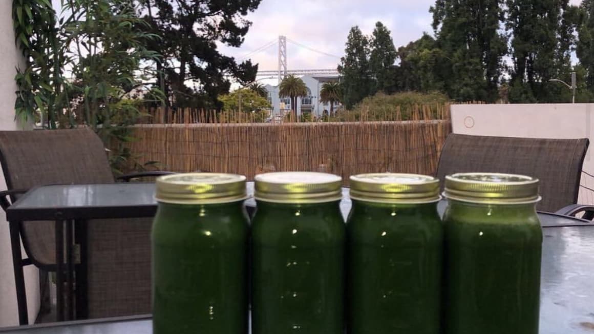 four jars of green juice apart of a green juice cleanse with the golden gate bride in the background in san francisco, california 