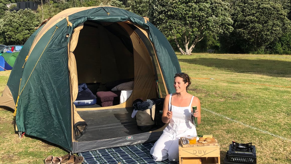 dani sitting outside a tent while camping in new zealand