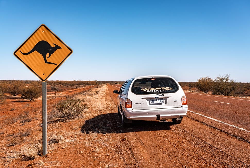 A car parked next to a kangaroo sign in the outback, Australia.