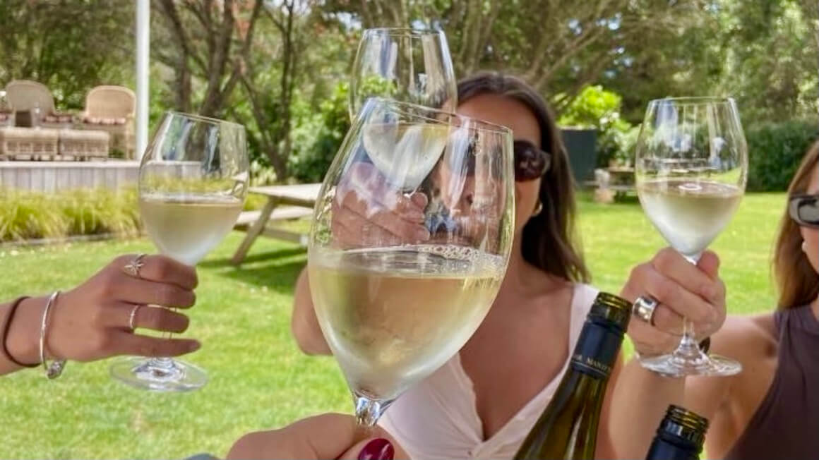 cheering white wine glasses at a vineyard in New Zealand