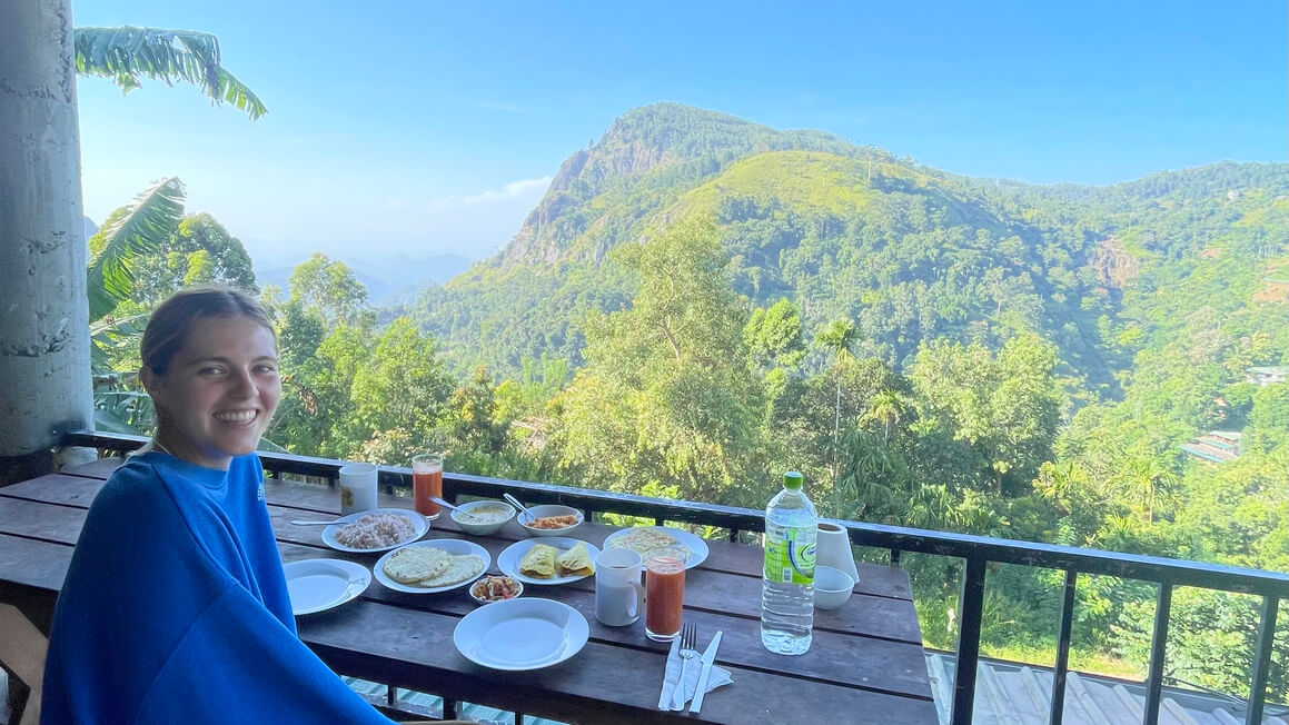 dani enjoying a free breakfast in sri lanka, looking over ella rock
