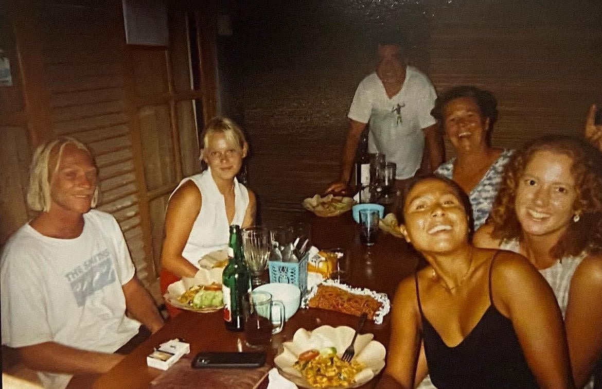 A grainy film photo of friends eating dinner at a warung in West Java Indonesia