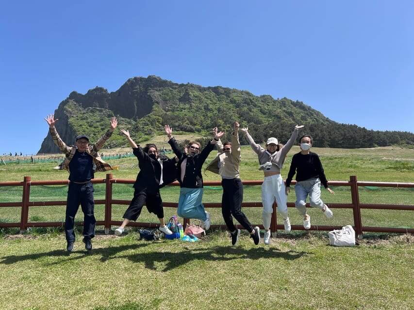 Travellers  jumping in a photo at 
 jeju Seongsan Ilchulbong Volcano