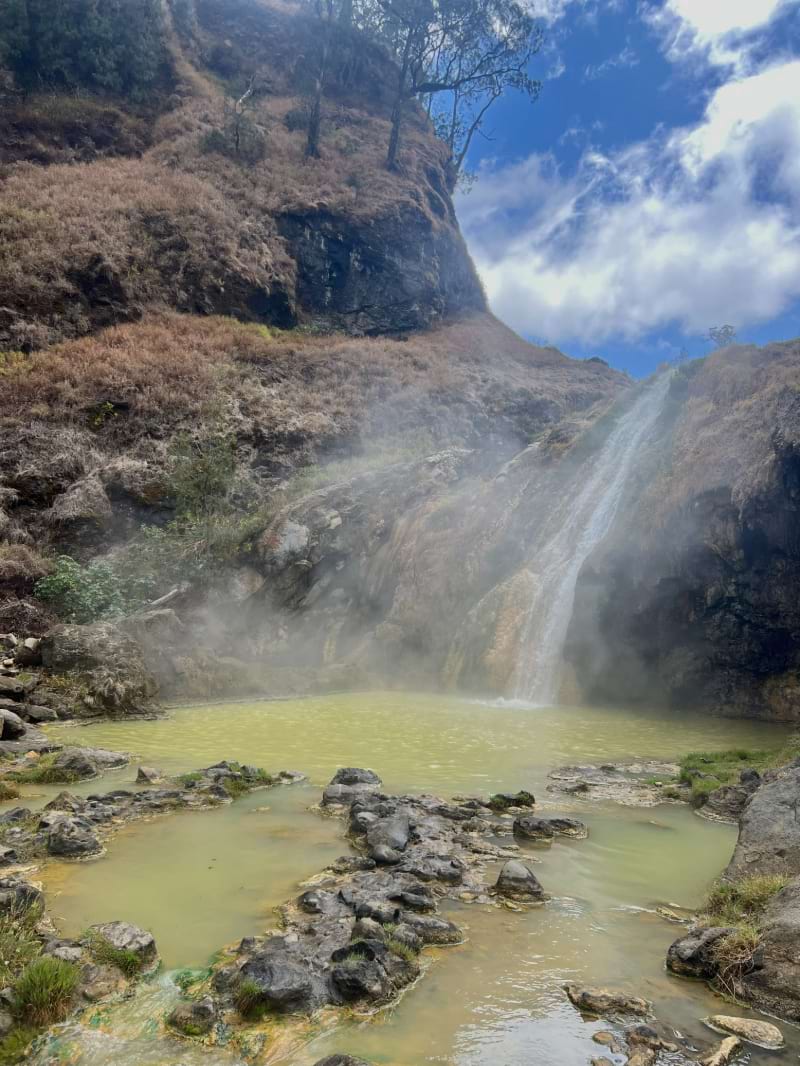 a waterfall of green hot springs from a volcano in mount rinjani