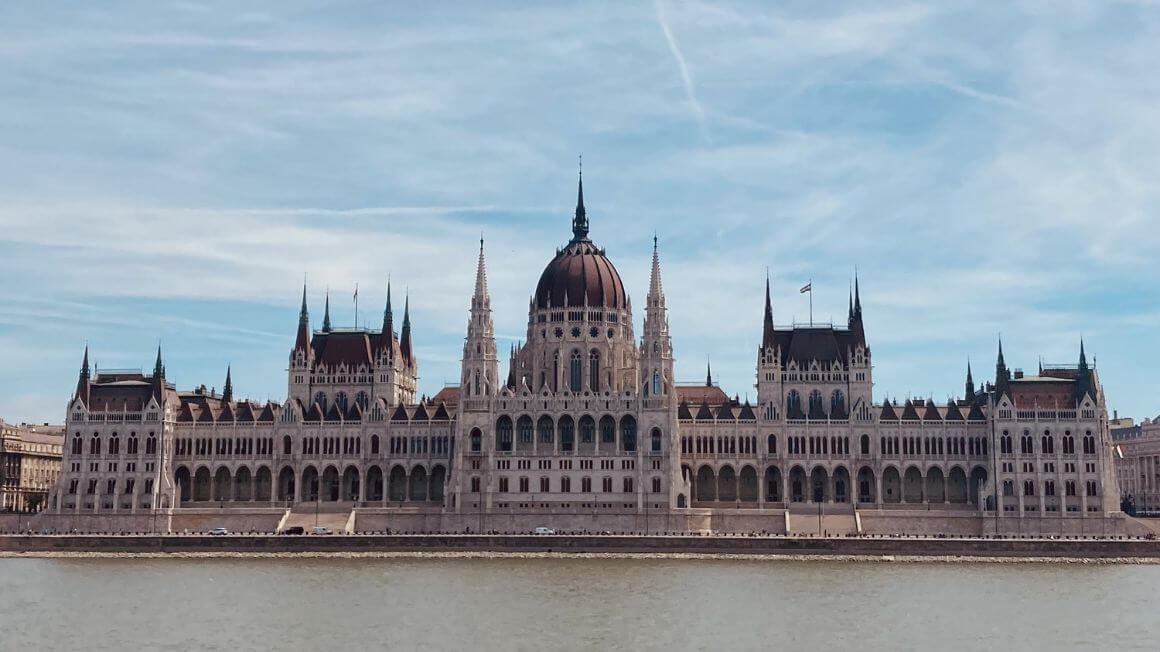 the parliament building in front of a river in budapest