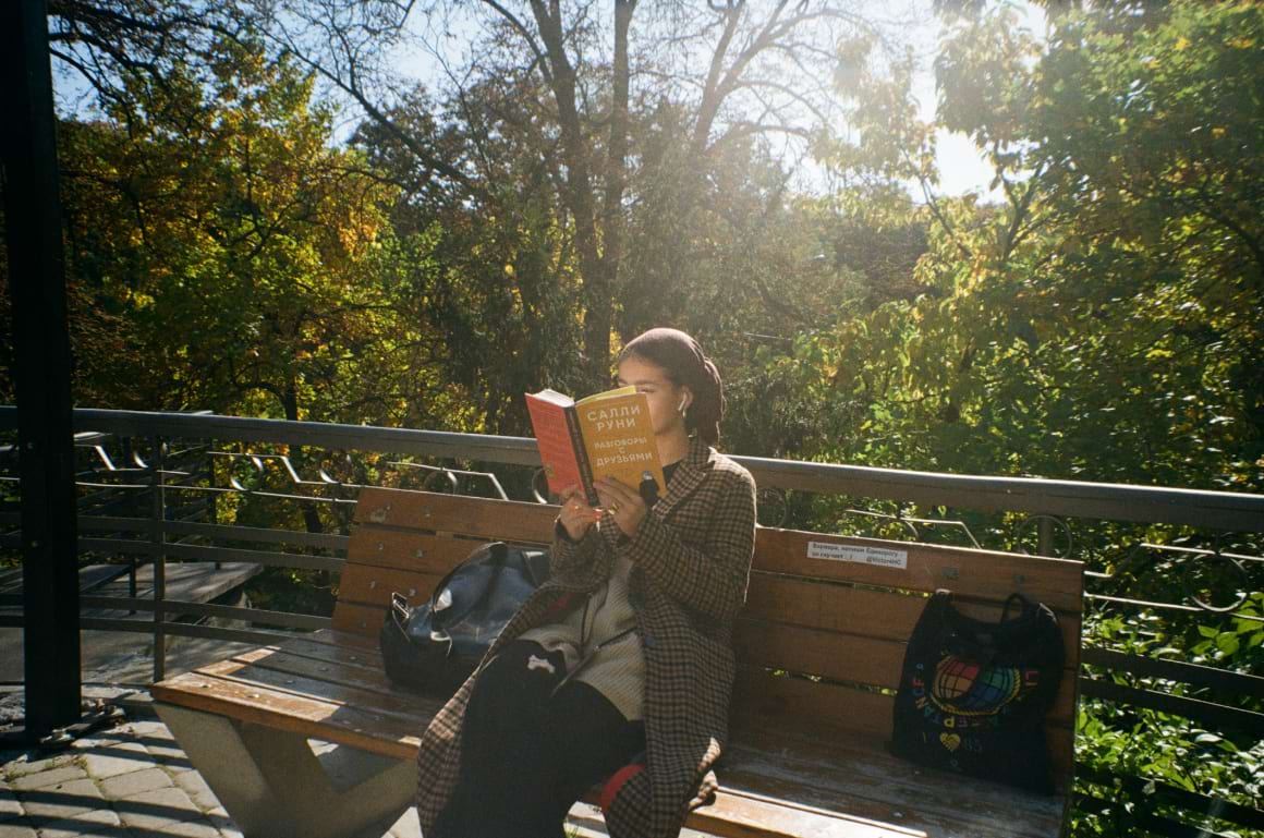 woman sitting on a bench reading a book