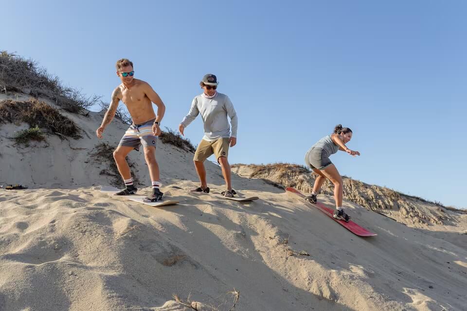 Go sandboarding over the beach dunes