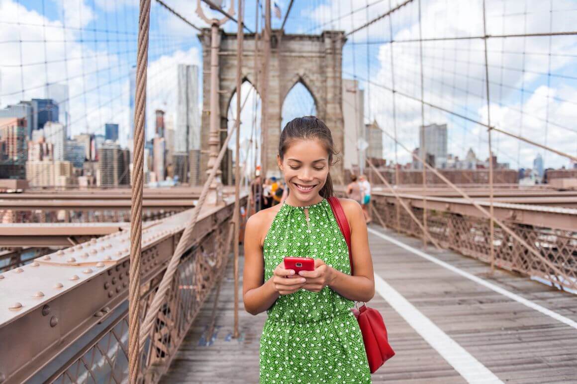 nyc brooklyn bridge woman using mobile