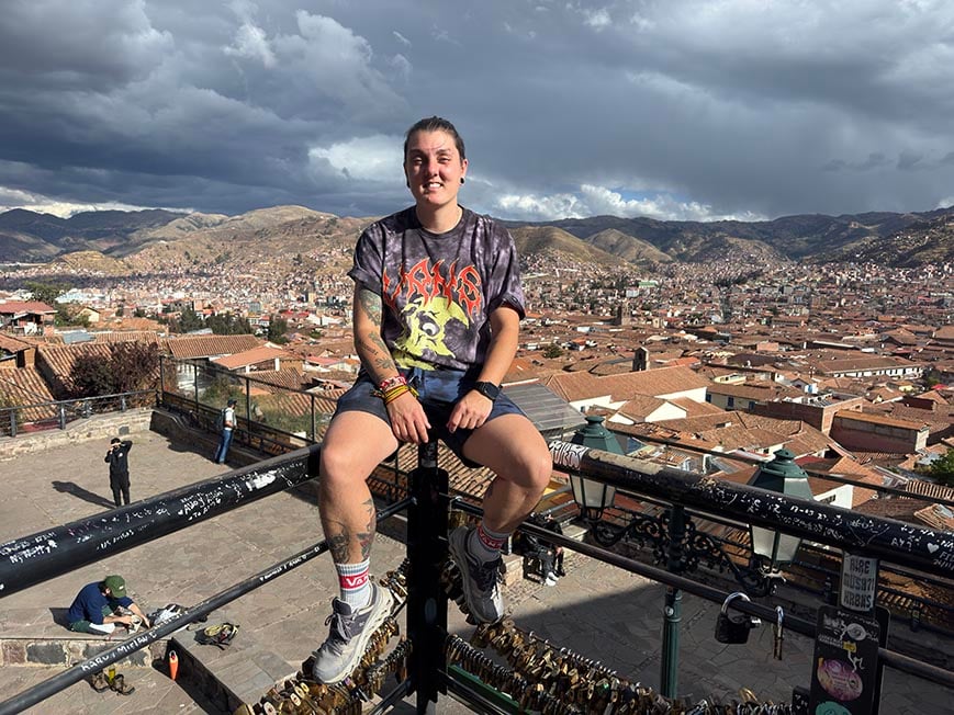 nic sitting on a fence over looking the city of Cusco, Peru below