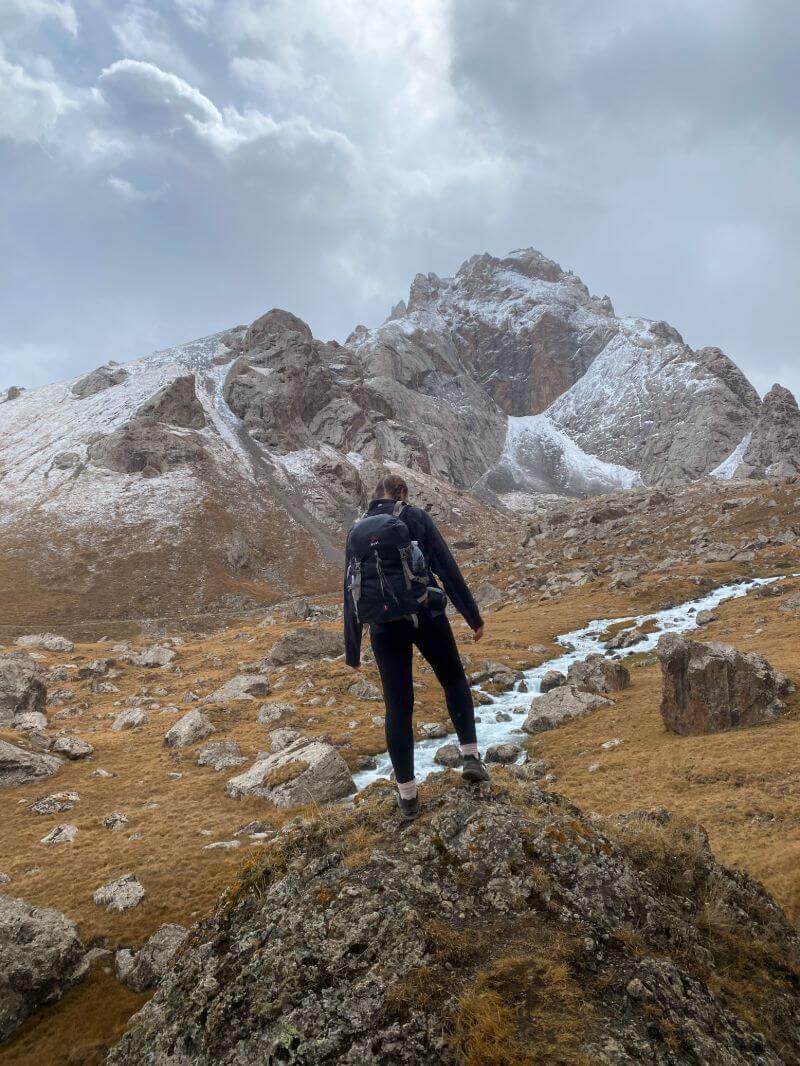 traveller hiking at kel suu snowy mountain