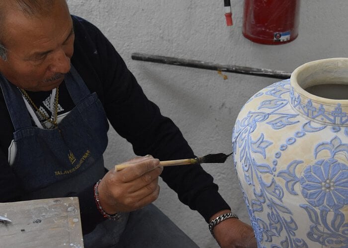 Man painting pottery on a Talavera Pottery Workshop
