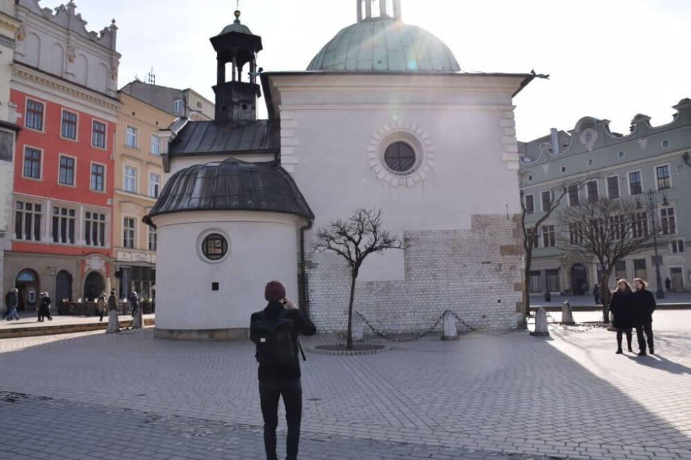 a man taking a photo of a building in Krakow Old Town