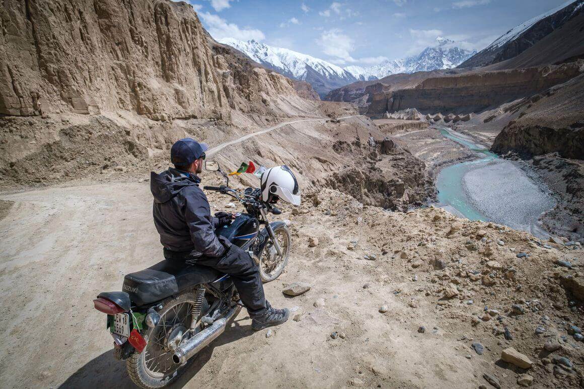 Will Hatton enjoys an epic view of mountains and a river in Pakistan from his motorbike