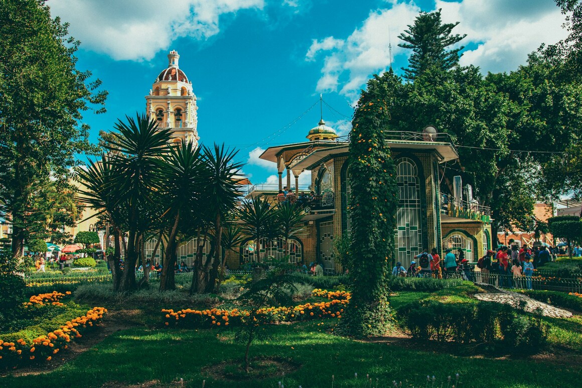 tan church in a lush green garden in atlixco pueblo mexico