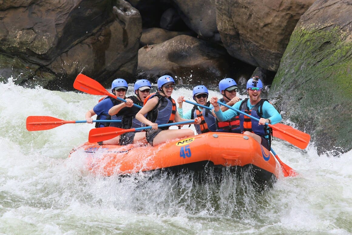 A group of friends white water rafting down a river