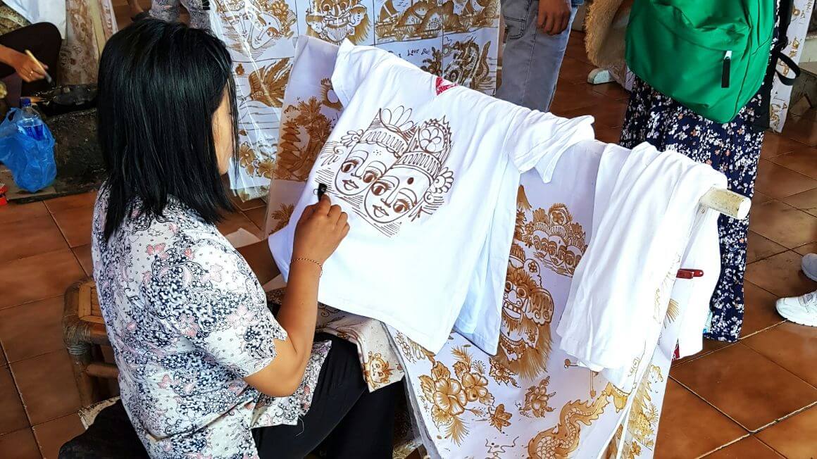 woman sitting on a chair and working on a batik clothes