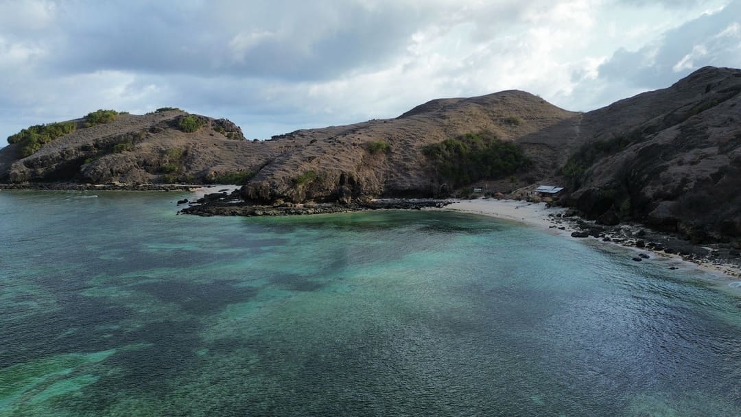 a drone shot of a hill and sea in dry season in lombok, indonesia