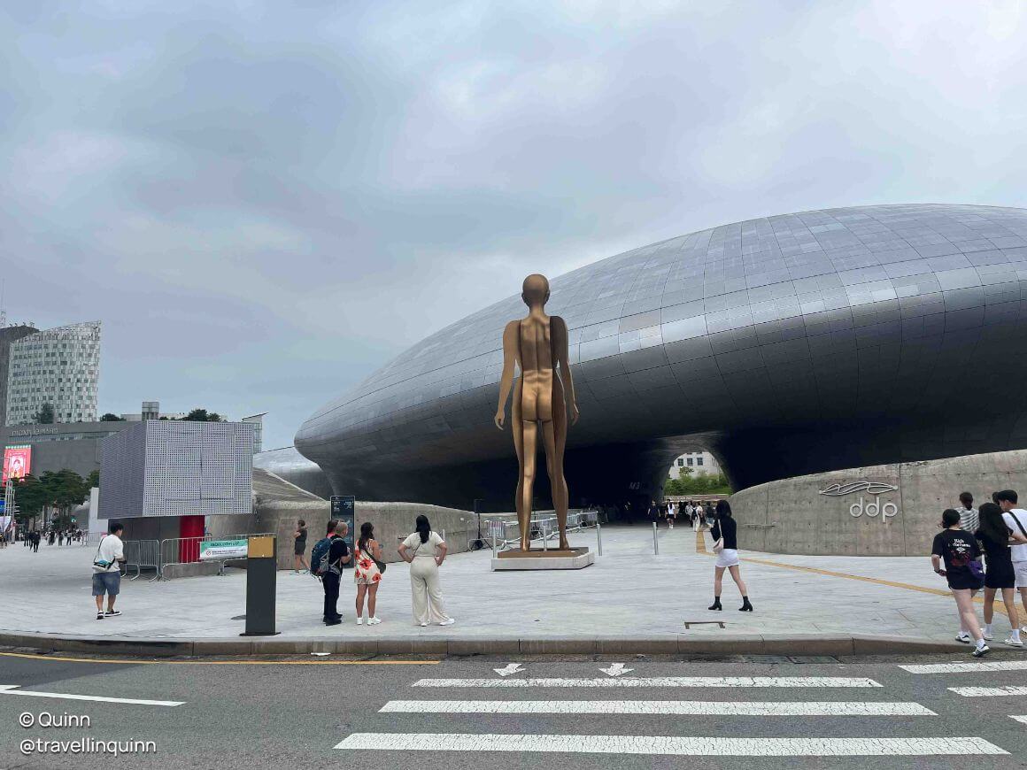 neofuturistic design of a statue with crowds around
