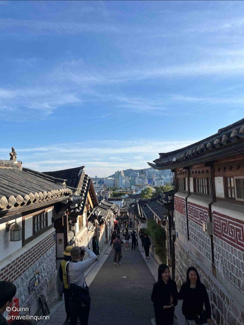 traditional Hanok structures with the modern buildings in the background