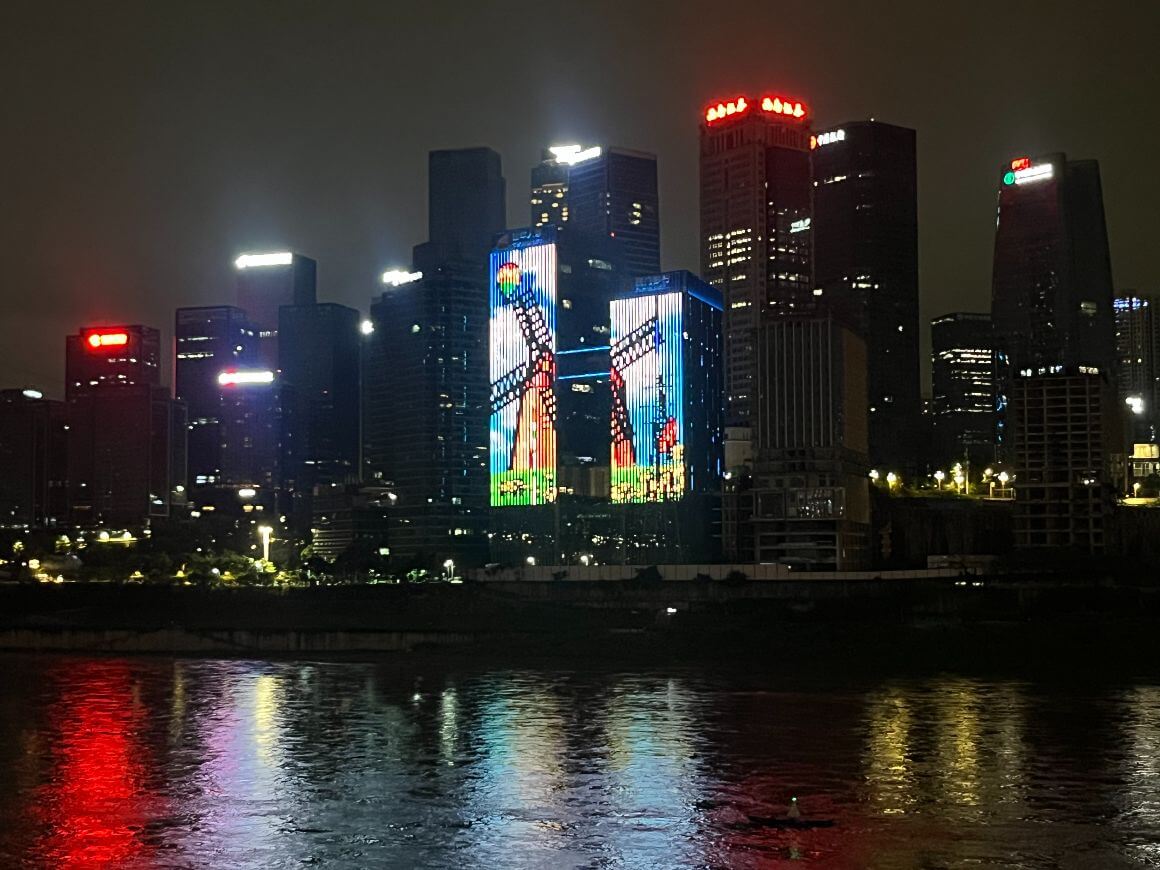 view of city skyscraper building lights at night along the river