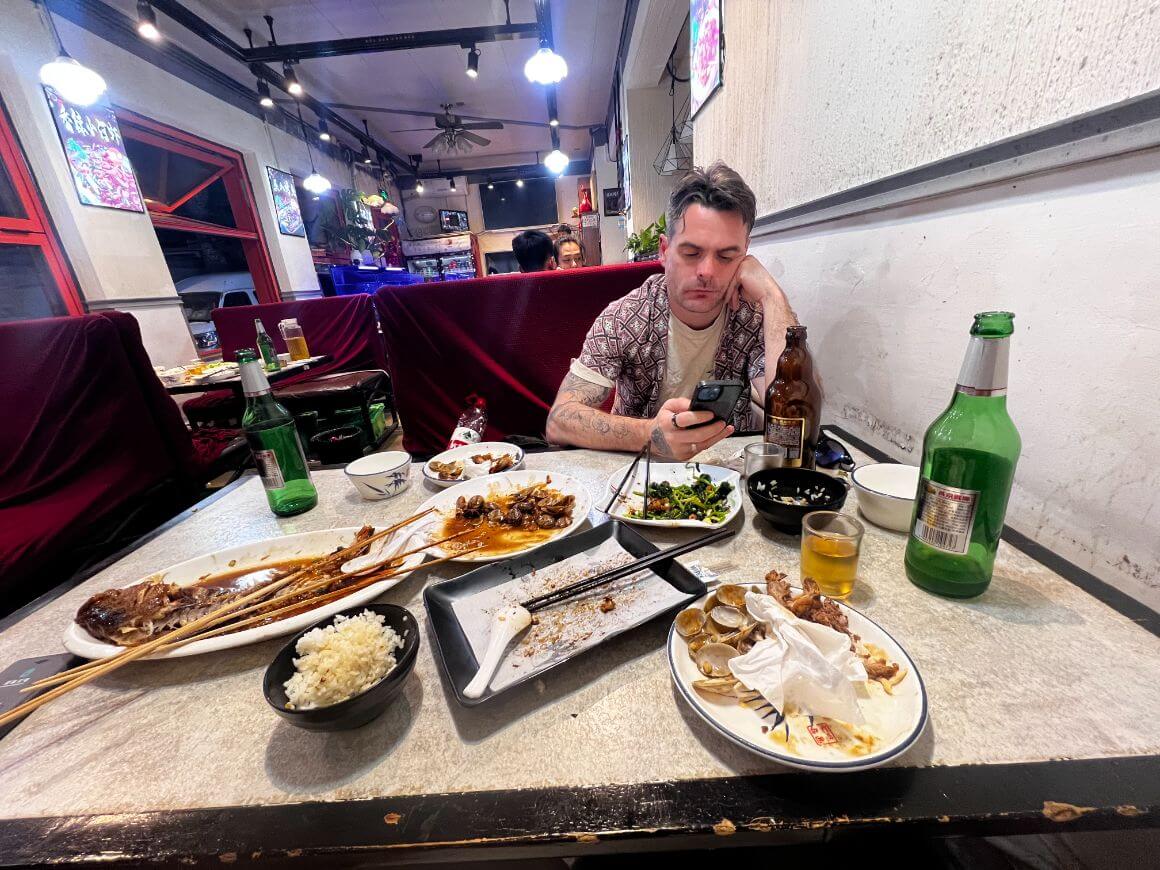 man using phone while dining at local chinese restaurant