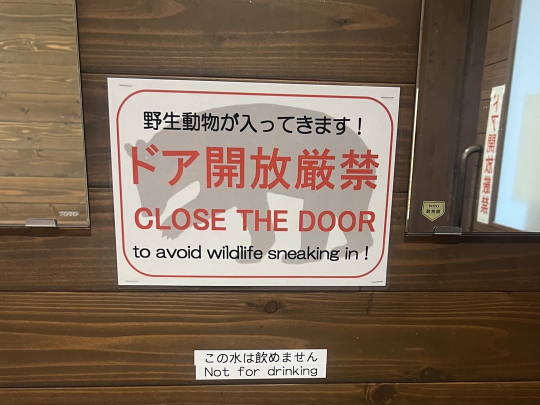 sign warning of bear sightings in kamokochi, japanese alps