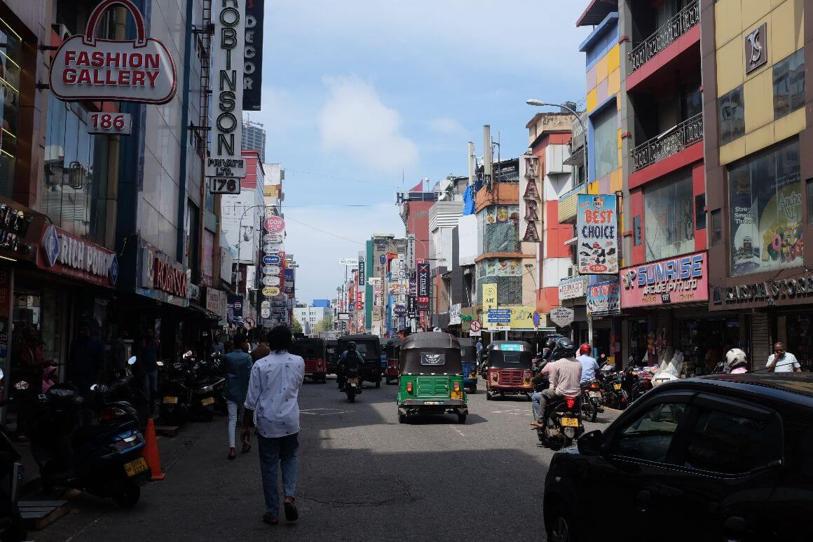 city traffic full of bikes, tricycles and city shops/building