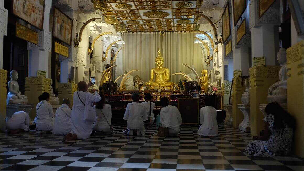 people wearing white praying and kneeling on temple altar