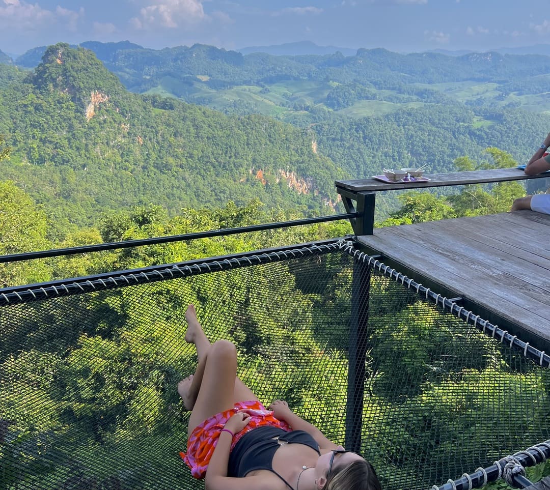 taya chilling in a hammock looking out at the mountains in pai, thailand