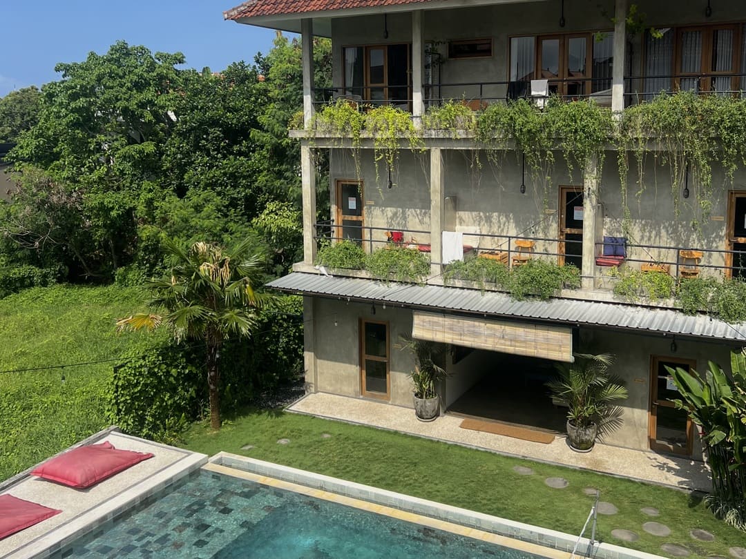 a pool and hostel amongst tropical gardens in canggu, indonesia
