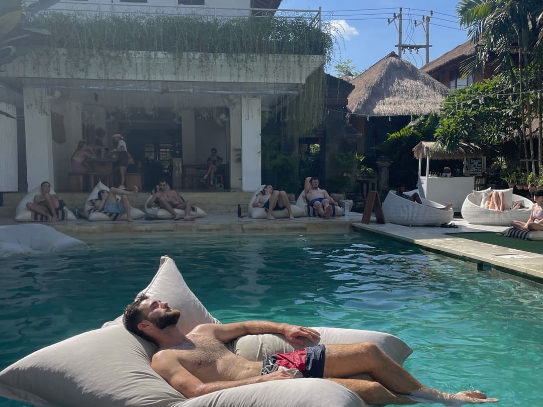backpackers chilling by the pool at puri garden hostel, ubud