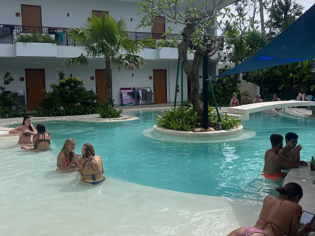 backpackers chilling around the pool at layday hostel in uluwatu