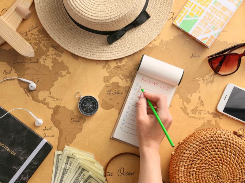 woman writing a travel packing list