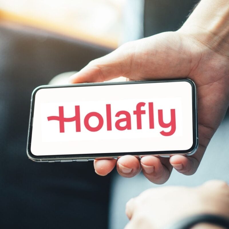 photo of a person holding a smartphone with Holafly logo