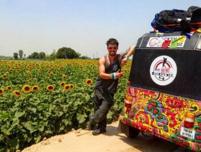will hatton standing next to his psychedelic tuk tuk in india