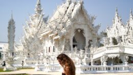a girl in front of a temple in thailand