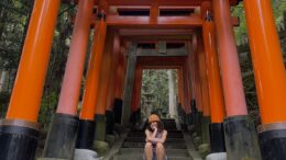 girl smiles for photo at a famous shrine in Kyoto, Japan