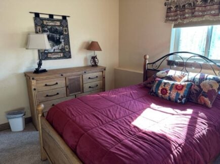 bed in mountain cabin by sunny window