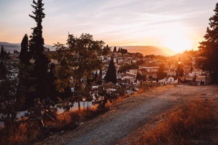 The sunsetting over the white buildings of Granada, Spain
