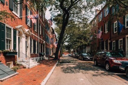 A street of red brick old houses and flags in Philadelphia, United States of America.