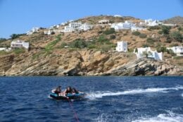 tubing/ biscuiting in ios with mountains and white houses on the hill behind, greece