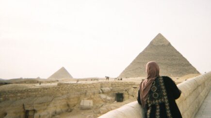 a woman looks at the pyramids in giza, cairo, egypt